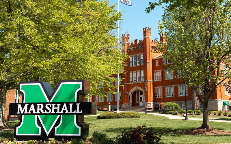 Large Marshall M sign in front of Old Main on Marshall University's Huntington campus