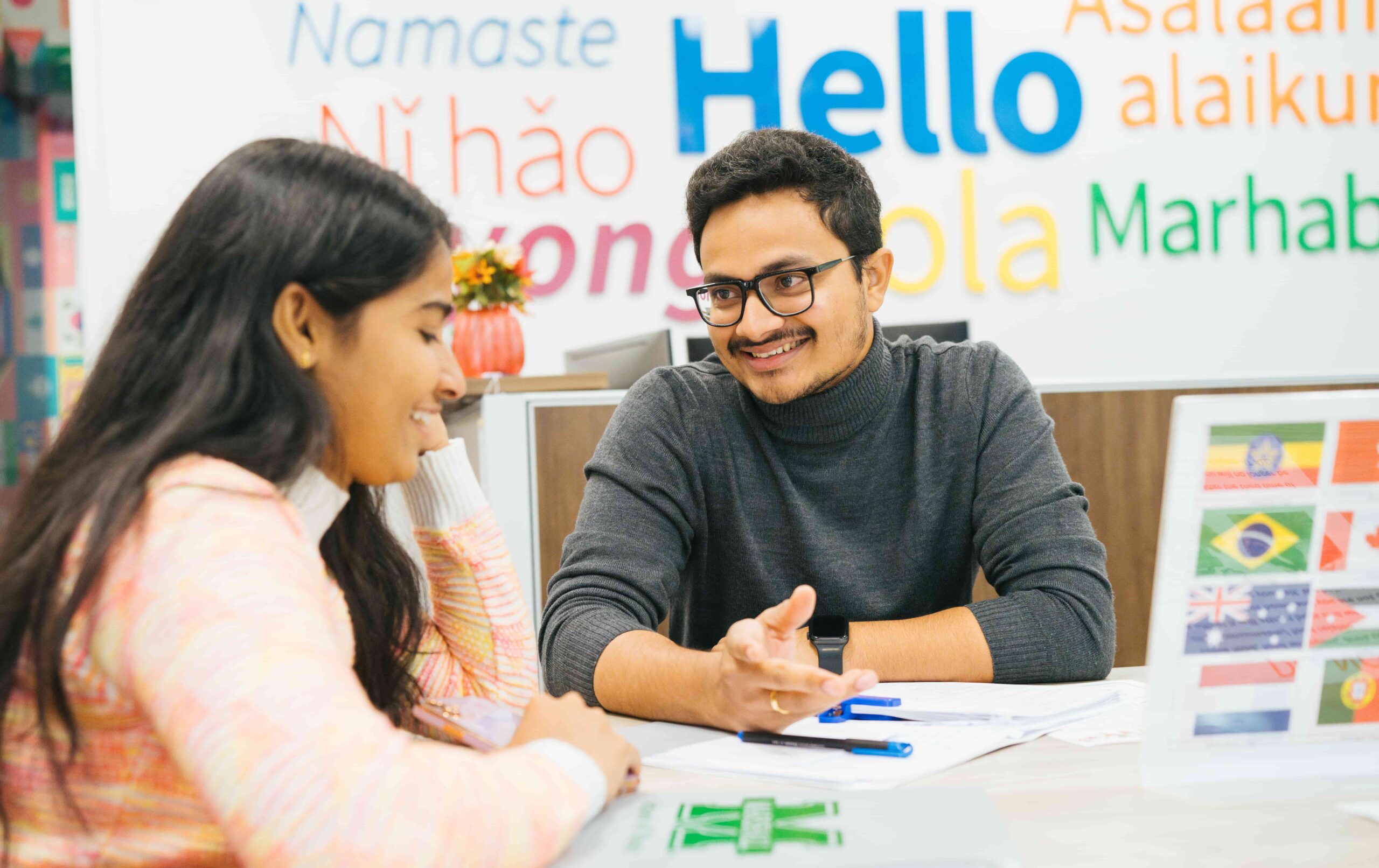 two international students sitting at a table talking to each other