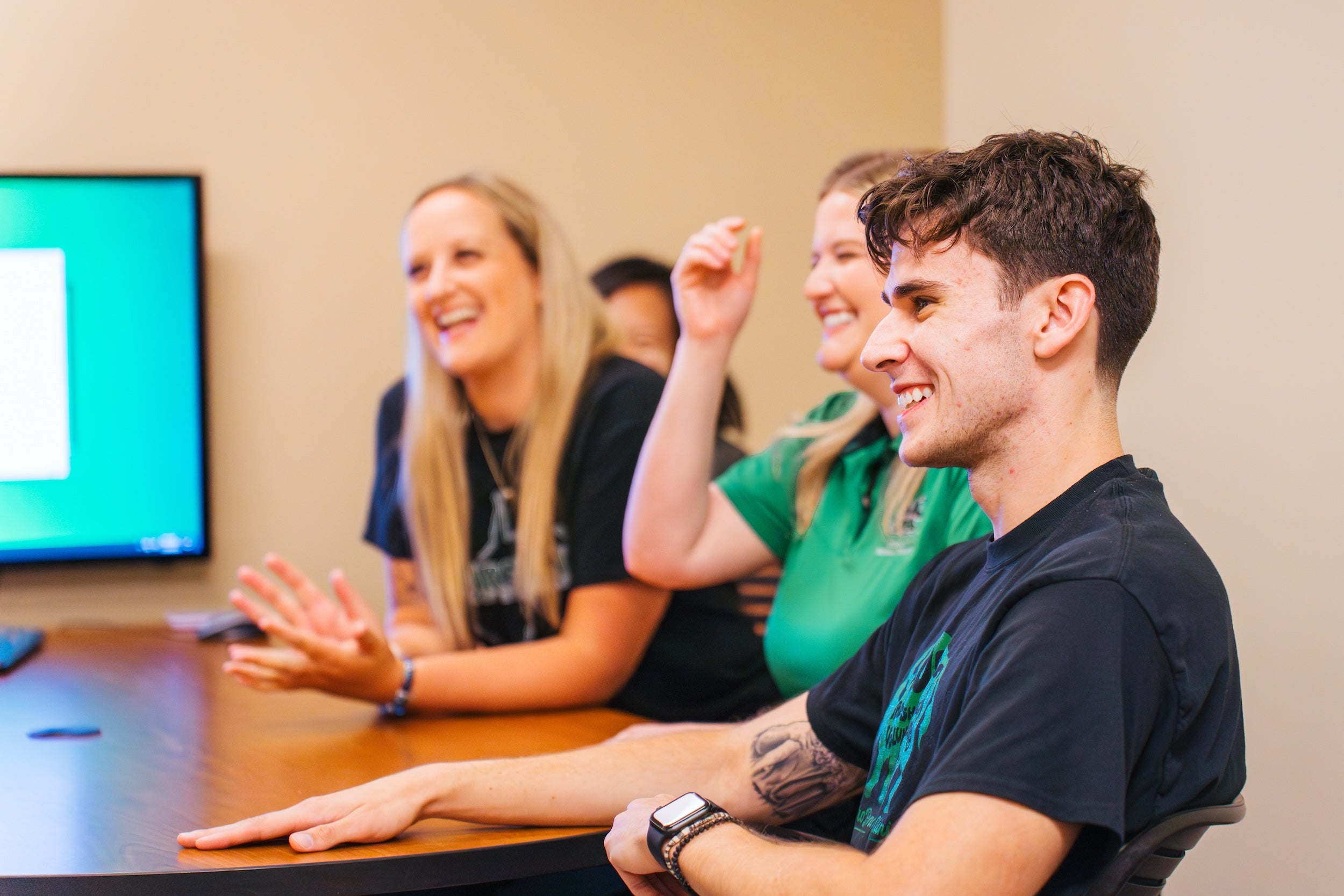 four PT students sitting at a table and smiling