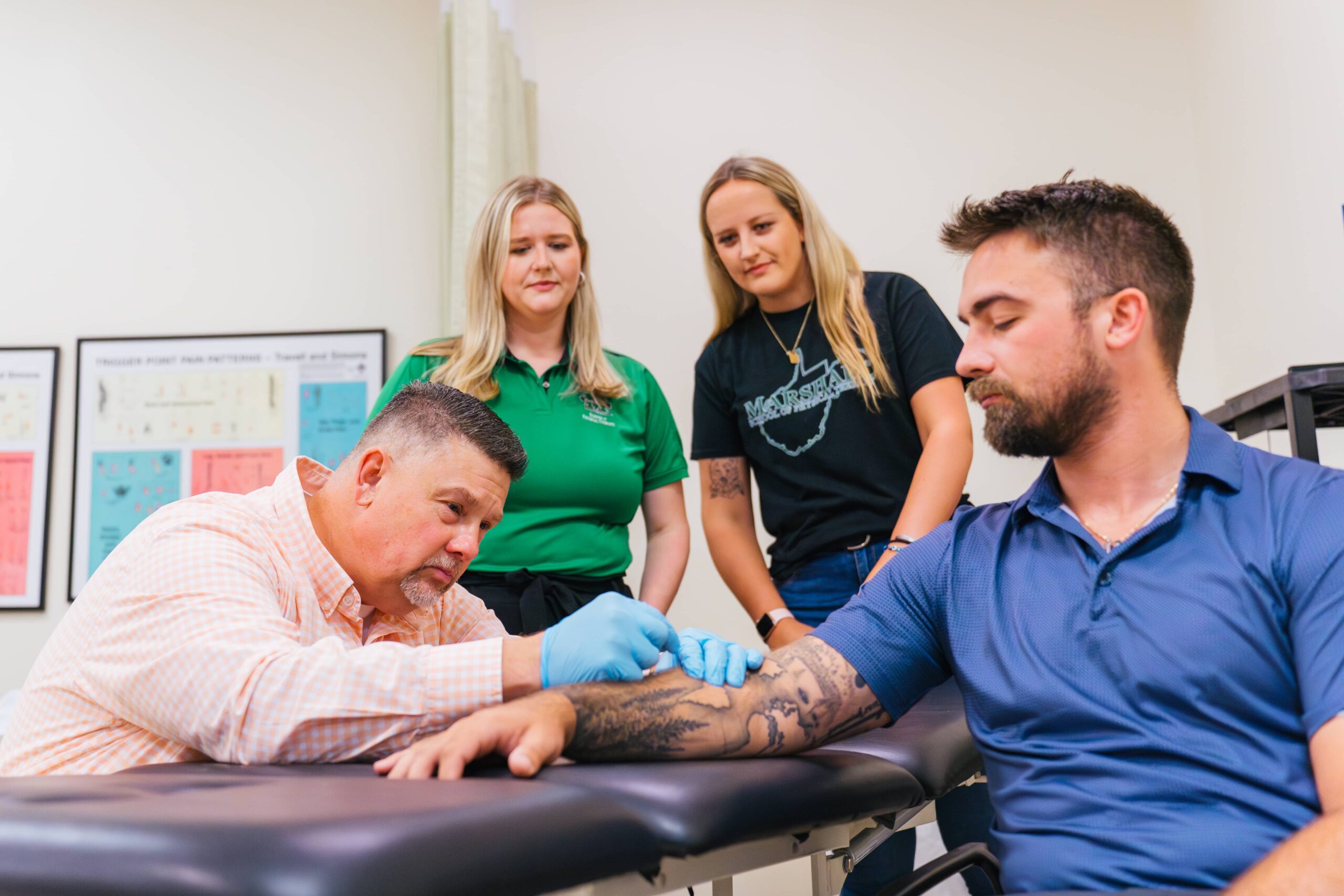 Director Davis performing PT on a test patient while two students observe